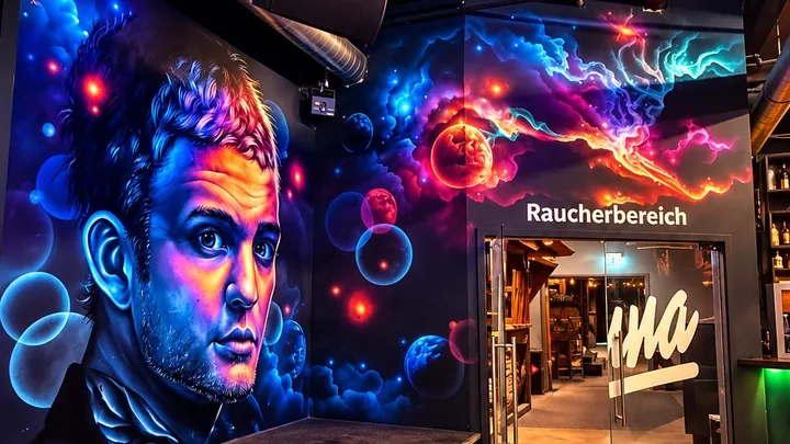 Gang zum Raucherbereich mit beleuchtetem Wandbild